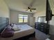 Cozy bedroom with carpet, a ceiling fan, and a large window for ample natural light at 1825 Cayman Cove Cir, St Cloud, FL 34772