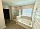 Bright bathroom featuring a tub, separate glass enclosed shower, and tile flooring at 18381 Oliver Twist Way, Winter Garden, FL 34787