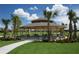 Community picnic pavilion with picnic tables surrounded by lush lawns and palm trees, an outdoor gathering space at 18381 Oliver Twist Way, Winter Garden, FL 34787