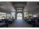 The covered patio area features multiple tables, chairs, and fans overlooking the pool and greenery at 18381 Oliver Twist Way, Winter Garden, FL 34787