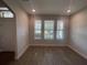 Well-lit living room features wood-look flooring and many windows offering natural light at 18381 Oliver Twist Way, Winter Garden, FL 34787