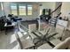 Inviting living room with wood-look flooring, large windows, a cozy seating area, and a glass dining table at 18381 Oliver Twist Way, Winter Garden, FL 34787