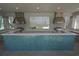 The outdoor kitchen features stainless steel grills, mosaic tile, and a view of the lake at 18381 Oliver Twist Way, Winter Garden, FL 34787