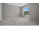 Cozy bedroom features a large window offering scenic views, plush carpet, and neutral walls at 2204 Hammock Moss Dr, Orlando, FL 32820