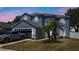 Charming two-story home with an attached garage, well-manicured lawn and tasteful landscaping with tropical plants at 2204 Hammock Moss Dr, Orlando, FL 32820