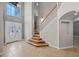 Grand foyer featuring wood staircase, decorative glass door, and tile flooring at 2204 Hammock Moss Dr, Orlando, FL 32820