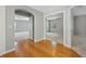 Hallway with light gray walls and natural hardwood floors with doorways leading to other rooms at 2204 Hammock Moss Dr, Orlando, FL 32820