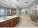 Main bathroom features a large tub, glass shower, double sinks, and a large mirror with great lighting at 2204 Hammock Moss Dr, Orlando, FL 32820