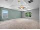 Expansive main bedroom with tray ceiling, multiple windows offering ample natural light, and soft carpet at 2204 Hammock Moss Dr, Orlando, FL 32820