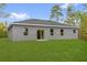 The house is surrounded by a big lawn and features glass sliding doors with great lighting and a gray exterior at 23 Fisher Run, Ocklawaha, FL 32179