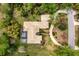 Stunning aerial view of a home featuring a screened pool, tile roof, driveway, lush landscaping, and mature trees at 2733 Deer Berry Ct, Longwood, FL 32779