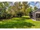 Beautiful lawn and wooded area behind the home featuring mature trees and partial pool enclosure at 2733 Deer Berry Ct, Longwood, FL 32779