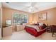 Bright bedroom featuring a decorative bed, ceiling fan, and a large window at 2733 Deer Berry Ct, Longwood, FL 32779