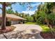 Long driveway leads to a home with a tile roof and a two-car garage with mature landscaping at 2733 Deer Berry Ct, Longwood, FL 32779