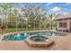 View of the in-ground pool and hot tub with screened-in enclosure and lush surroundings at 2733 Deer Berry Ct, Longwood, FL 32779