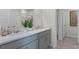 Bright bathroom featuring a double sink vanity, gray cabinets, white countertops and plank flooring at 2907 Moulin Rd, Davenport, FL 33837