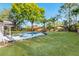 Beautiful backyard with an inviting pool, surrounded by lush lawn and mature trees at 2952 Ashwood Ct, Apopka, FL 32703