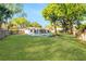 Expansive backyard with lush green lawn, mature trees, and a sparkling pool at 2952 Ashwood Ct, Apopka, FL 32703