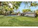 Spacious backyard featuring a well-maintained lawn, sparkling pool, and mature trees at 2952 Ashwood Ct, Apopka, FL 32703