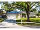 Charming single-story home with manicured lawn, stone accents, gray metal roof, and a two-car garage at 2952 Ashwood Ct, Apopka, FL 32703