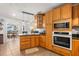 Bright kitchen with wooden cabinetry, stainless steel microwave and oven, flowing to an adjacent dining area at 337 Ohio Ave, St Cloud, FL 34769