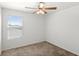 Bright, carpeted bedroom with a ceiling fan and a large window at 3936 Fescue St, Clermont, FL 34714