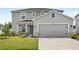 Two-story home features gray stucco, stone accents, a gray garage door, and a well-manicured lawn at 3936 Fescue St, Clermont, FL 34714