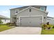 Two-story home features gray stucco, stone accents, a gray garage door, and a well-manicured lawn at 3936 Fescue St, Clermont, FL 34714