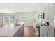 A well-lit kitchen featuring an island with a double sink and gray lower cabinets at 3936 Fescue St, Clermont, FL 34714