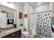 A bathroom shows a granite countertop, decorative shower curtain, vanity mirror and natural light at 3964 Lightning Ct, Sanford, FL 32773