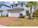 Charming two-story home with a brick driveway, tidy lawn, and a beautiful palm tree accenting the entrance at 3964 Lightning Ct, Sanford, FL 32773