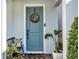 Inviting entryway features a light blue door with a wreath and cozy bench on a brick walkway at 3964 Lightning Ct, Sanford, FL 32773