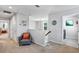 This hallway shows neutral carpet, white walls, gray chair with orange pillow and an overhead chandelier at 3964 Lightning Ct, Sanford, FL 32773