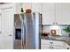 Close-up of a stainless steel refrigerator, granite countertops, and white cabinetry in the kitchen at 3964 Lightning Ct, Sanford, FL 32773