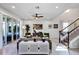 Bright living room with a ceiling fan, staircase, and sliding glass doors to the backyard at 3964 Lightning Ct, Sanford, FL 32773