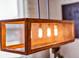 A close-up of a rectangular pendant light shows a wood frame with decorative mesh and three lights at 3964 Lightning Ct, Sanford, FL 32773