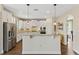 Well-lit kitchen features white cabinetry, stainless appliances, granite countertops, and a breakfast bar at 420 Lone Heron Way, Winter Garden, FL 34787