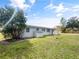 View of home exterior showcasing back of home and lush green yard with mature trees at 46 Morning Glory Dr, Debary, FL 32713