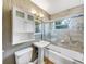 This bathroom features tiled walls, a pedestal sink, a shower-tub combo, and a stylish cabinet at 46 Morning Glory Dr, Debary, FL 32713