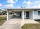 Exterior view features a carport, front door with house number, and landscaped yard at 46 Morning Glory Dr, Debary, FL 32713
