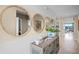 Bright entryway with coastal accents including round mirrors, woven buffet table, and neutral wall colors at 5223 Ligonberry St, Lakeland, FL 33811