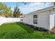 A serene backyard features lush green grass, flower beds, and a private white fence at 5600 Revelwood Loop, Winter Park, FL 32792
