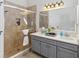 Elegant bathroom with double vanity, stone shower, updated lighting, and luxurious finishes at 5600 Revelwood Loop, Winter Park, FL 32792