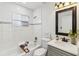 Modern bathroom featuring white subway tiles, a tub, and a vanity with dark fixtures at 5600 Revelwood Loop, Winter Park, FL 32792