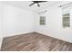 Neutral bedroom featuring wood-look floors, ceiling fan, and natural light at 6412 Queens Borough Ave # 215, Orlando, FL 32835