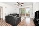 Bright living room with hardwood floors, large windows, and a comfortable black sofa at 6412 Queens Borough Ave # 215, Orlando, FL 32835