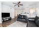 Image of a living room with hardwood floors, ceiling fan, and black couches at 6412 Queens Borough Ave # 215, Orlando, FL 32835