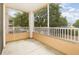 Screened patio featuring white railings and large trees providing privacy and shade at 6412 Queens Borough Ave # 215, Orlando, FL 32835