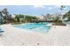 Community pool with a diving board and marked lanes, surrounded by lush landscaping and lounge chairs at 6412 Queens Borough Ave # 215, Orlando, FL 32835