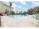 Community pool surrounded by lounge chairs and tropical landscaping for relaxation and enjoyment at 6412 Queens Borough Ave # 215, Orlando, FL 32835